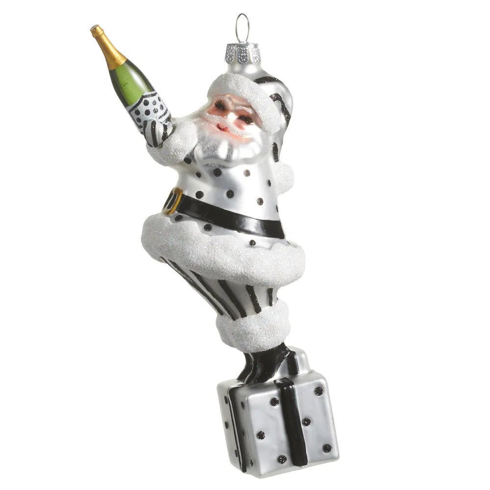Black and white polka dot Santa glass ornament holding champagne bottle on gift box