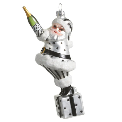 Black and white polka dot Santa glass ornament holding champagne bottle on gift box