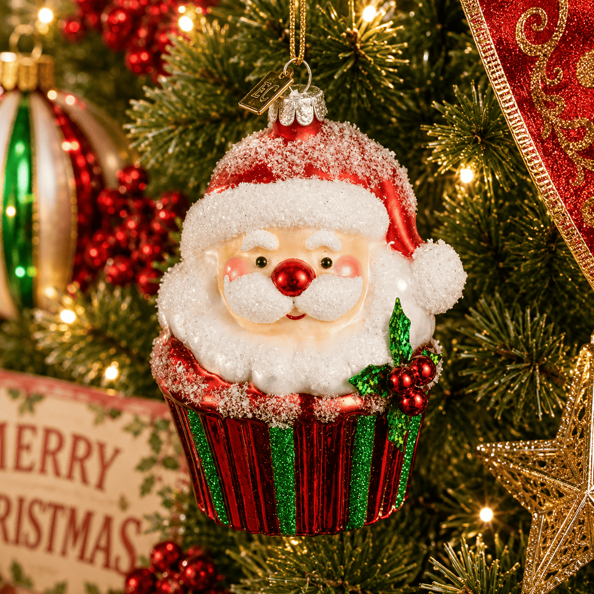 Glass Santa Claus cupcake ornament with glittery red and green wrapper, holly accent, hanging on Christmas tree