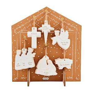 White ceramic nativity Christmas ornaments displayed on wooden stable backdrop, 6 styles