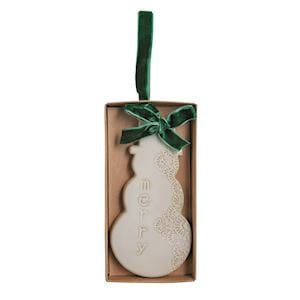 White ceramic snowman ornament with green velvet bow in kraft gift box