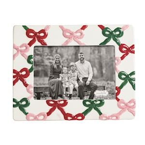 White ceramic photo frame with pink red and green bow pattern holding family portrait