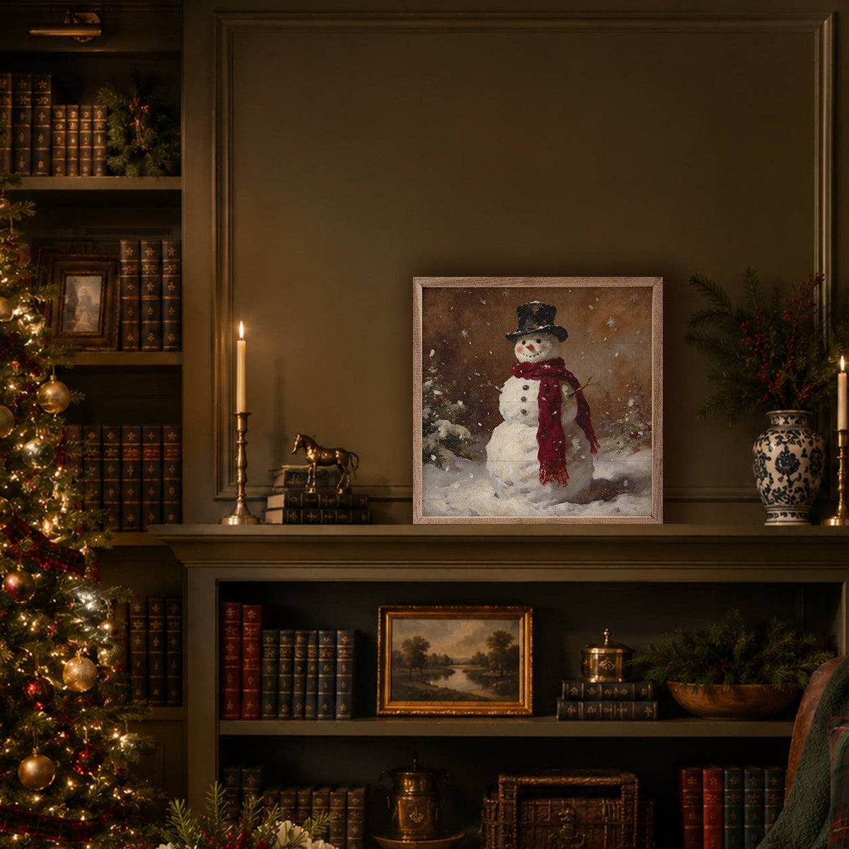 Framed woodland snowman painting displayed on a bookshelf in a cozy Christmas library setting.