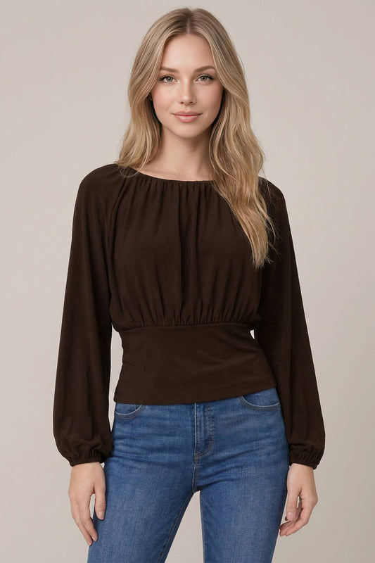 Dark brown ruched balloon sleeve knit top with fitted waistband paired with blue jeans
