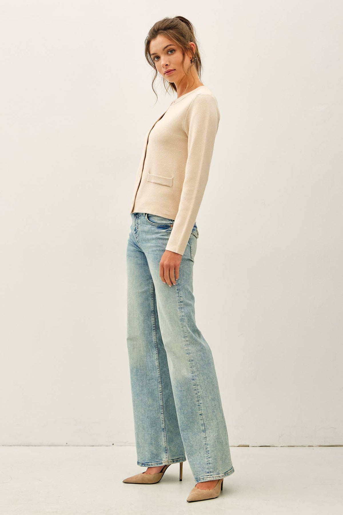 Cream crewneck snap button cardigan with front pocket detail, paired with light wash jeans