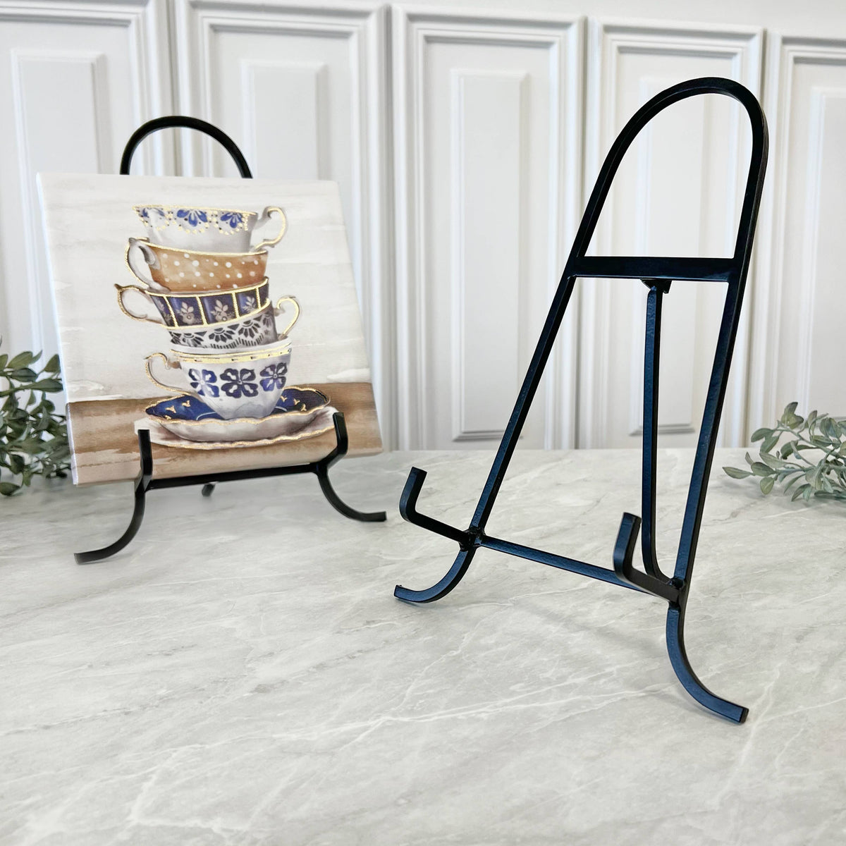 Black wrought iron display easel, 11 inches tall, shown with decorative tile on marble surface