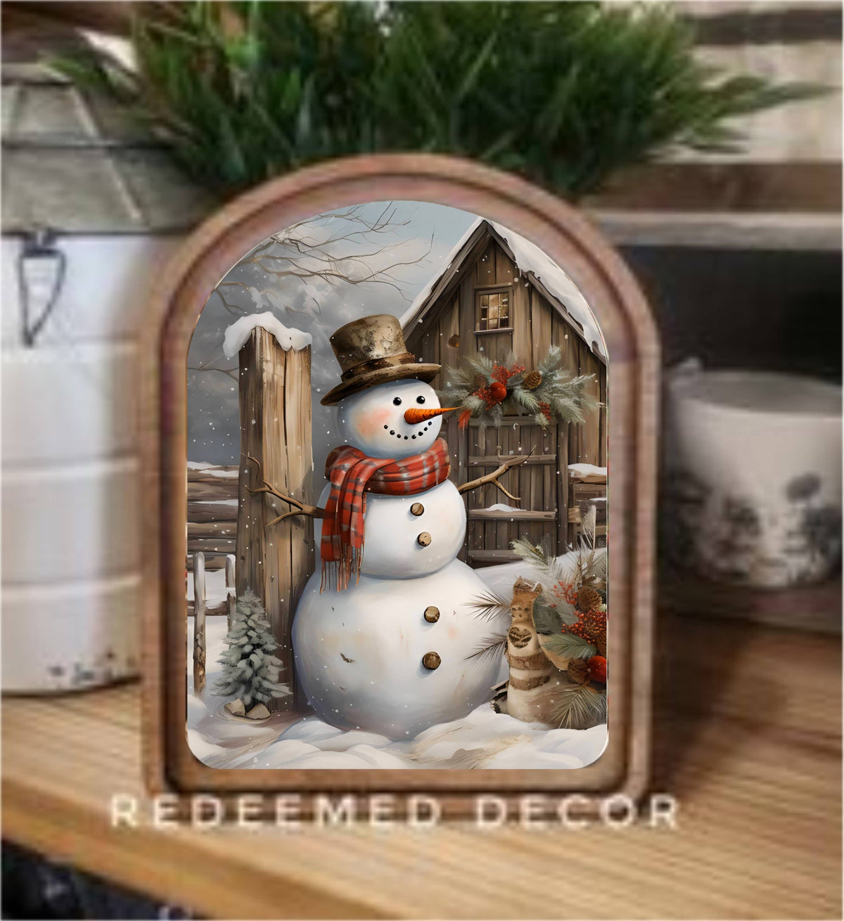 Arched wood-framed canvas art featuring a rustic snowman outside a snowy barn