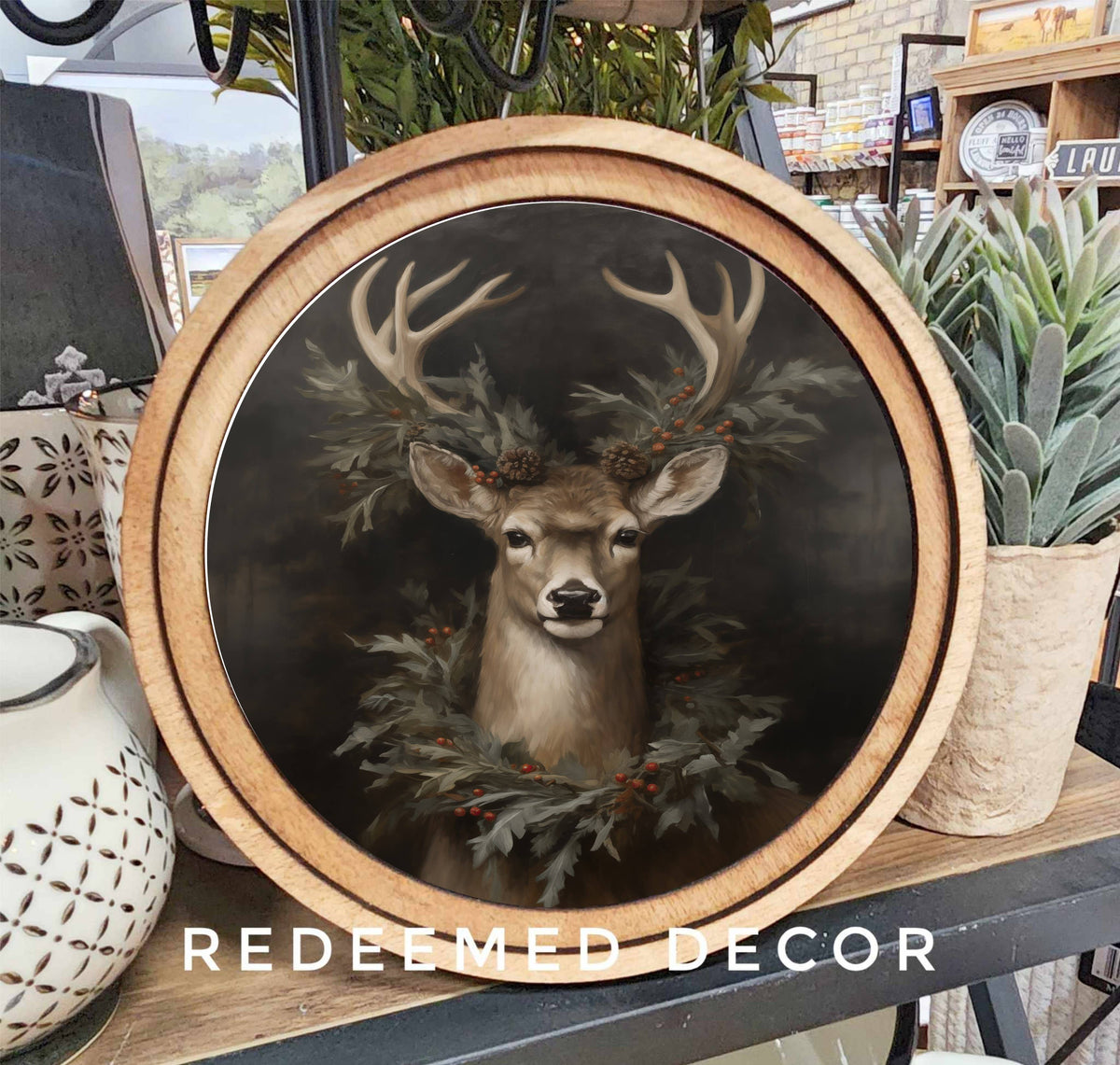 Round framed deer portrait with antlers and evergreen wreath in wood frame