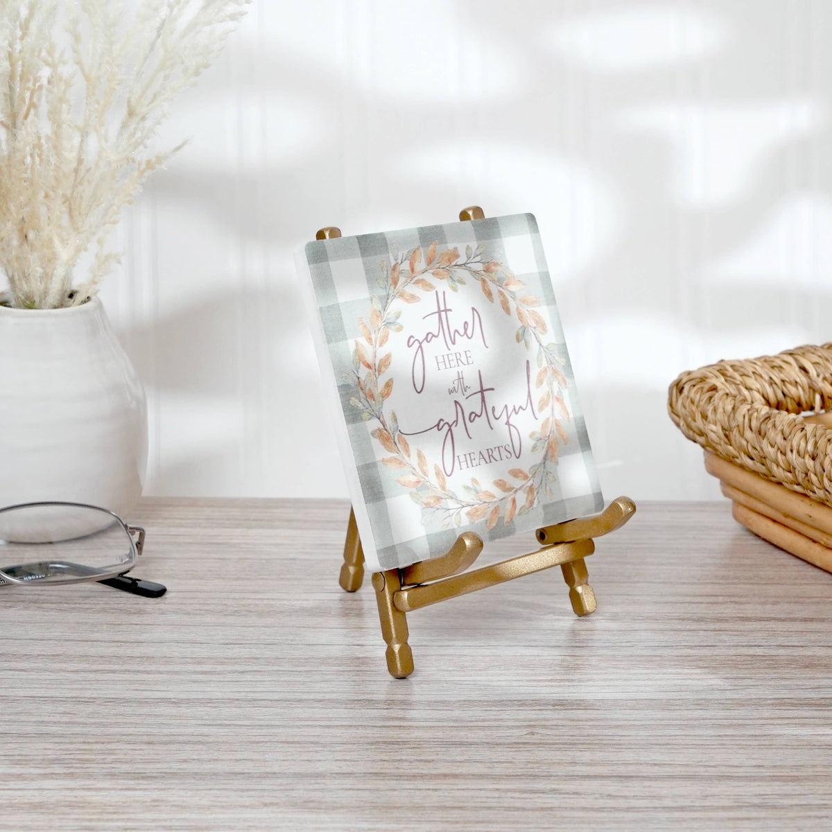 Gold satin metal mini easel displaying a decorative fall harvest sign on wood surface