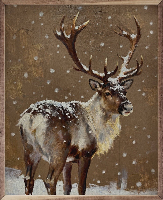 Framed oil painting of a reindeer with snow-dusted antlers standing in falling snow