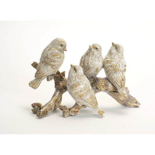 Four glittery cream and gold bird figurines perched on a decorative resin branch