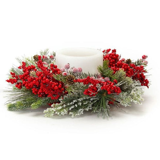 Festive candle ring with red berries, frosted pine branches, and pinecones surrounding a white pillar candle