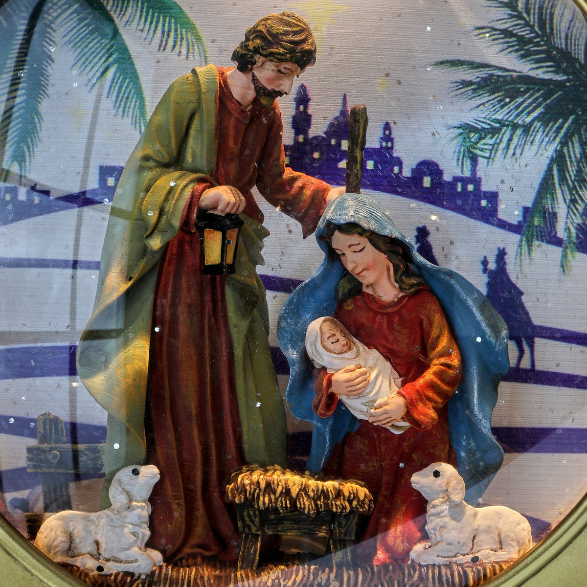 Globe ornament with Holy Family nativity scene, LED-lit, featuring Mary, Joseph, baby Jesus, and lambs