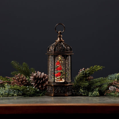 Antique bronze lantern-style snow globe with red cardinal birds on a Christmas tree inside