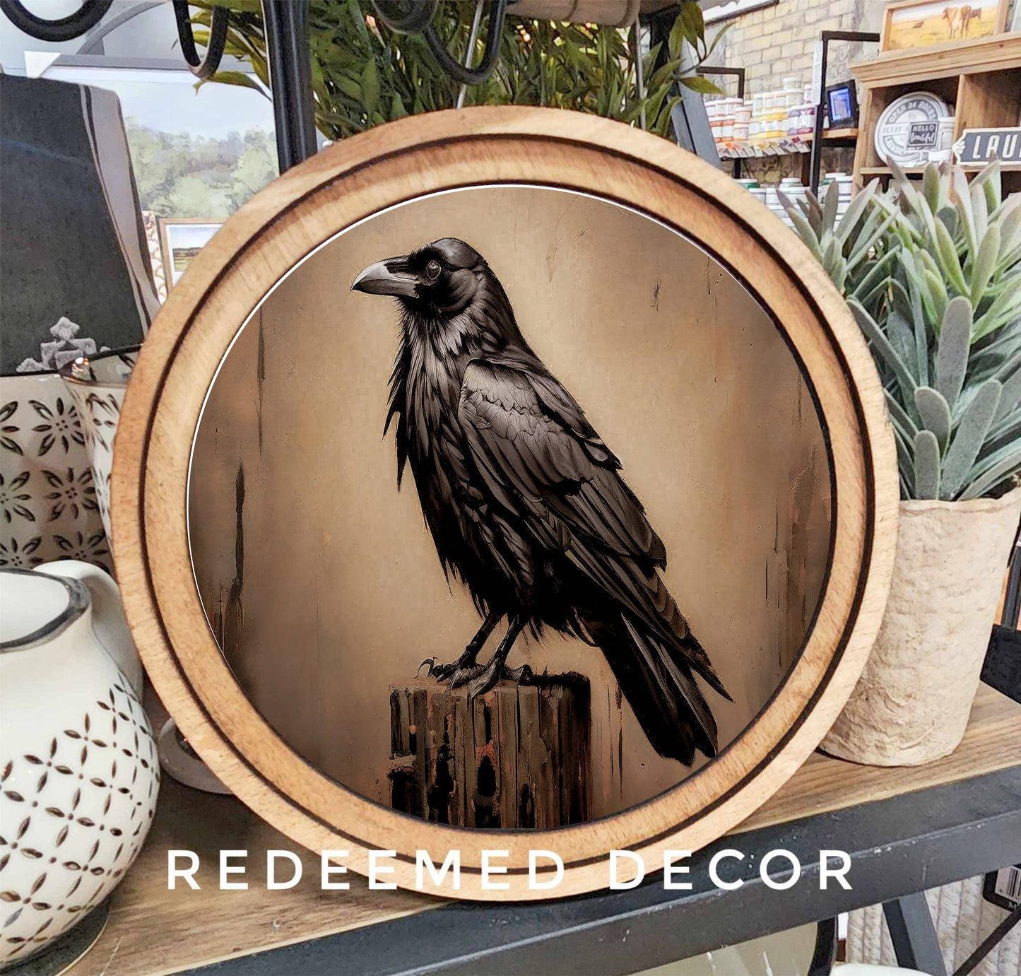 Round wood-framed canvas wall art featuring a black raven perched on a post
