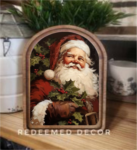 Arched wood-framed vintage Santa canvas art with holly berries on wood shelf