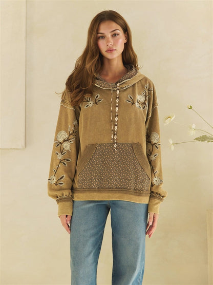 Olive mineral-wash hoodie with floral embroidery, printed pocket, and drawstring detail