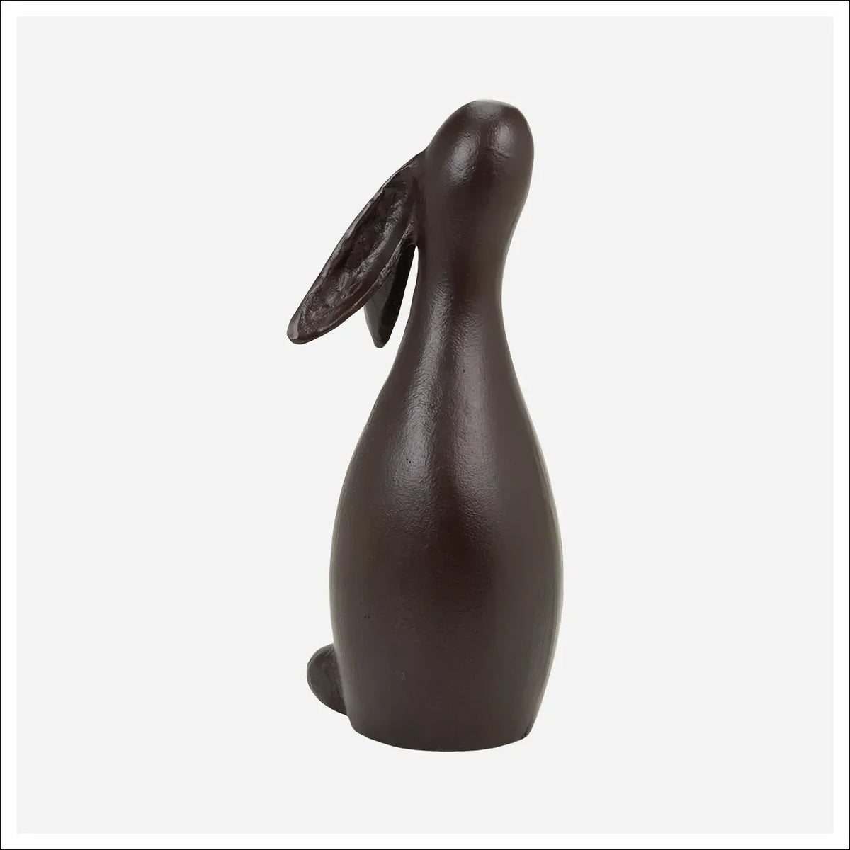 Dark brown cast iron hare sculpture with floppy ears gazing upward