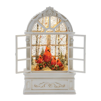 Illuminated snow globe shaped as an arched window with red cardinals in a winter forest scene
