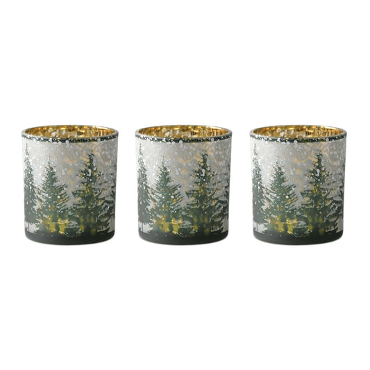 Set of three glass votive holders with snowy pine tree forest design and gold metallic interior