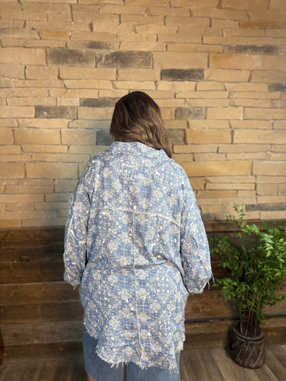 Blue paisley printed button down shirt with frayed hem, back view