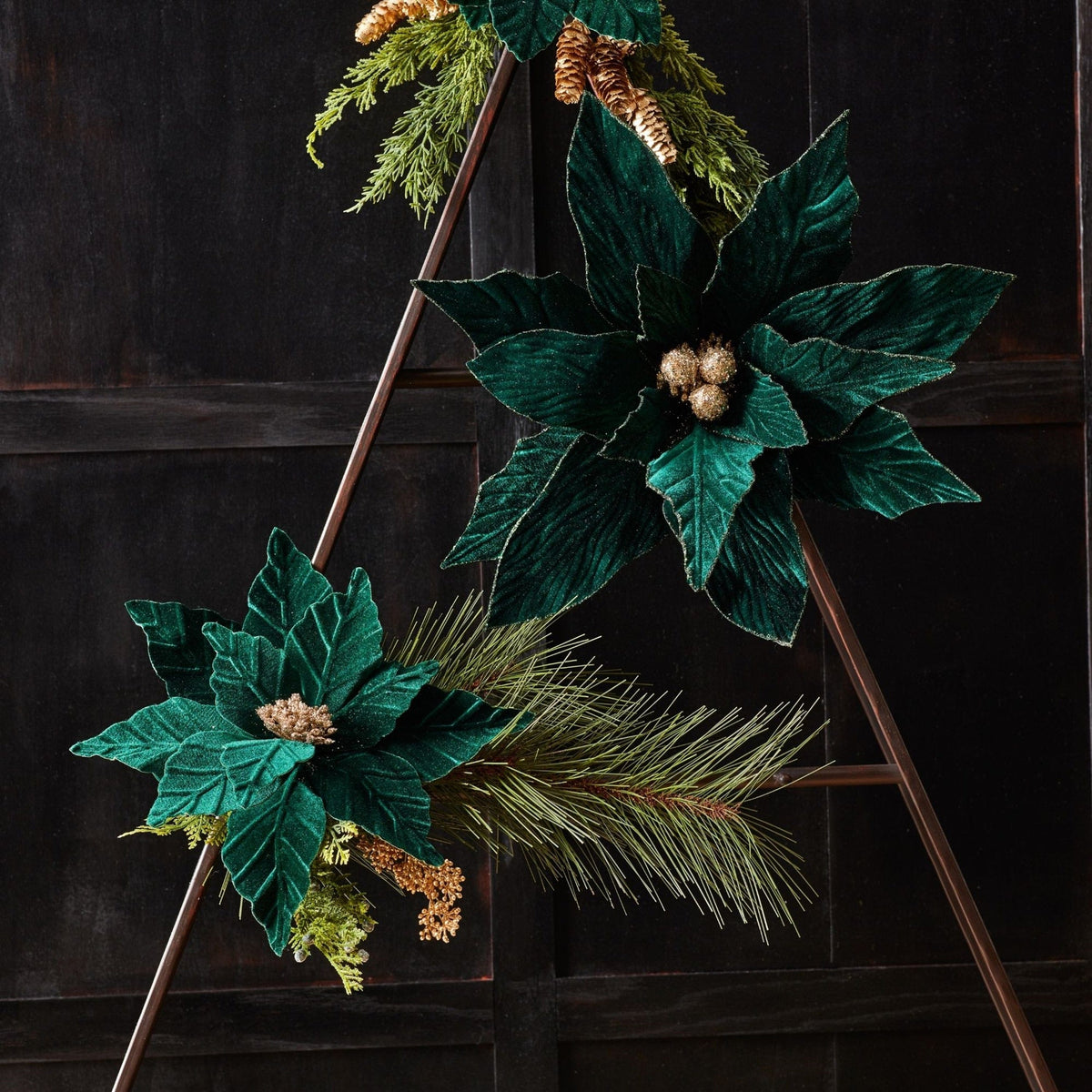 Velvet poinsettia stems with gold berries and pine accents displayed on a decorative ladder