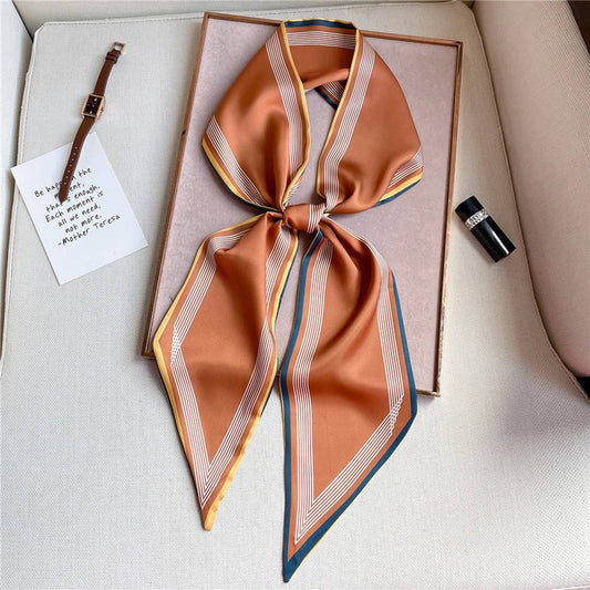 ACCITY burnt orange silk scarf with geometric stripe border, tied in knot
