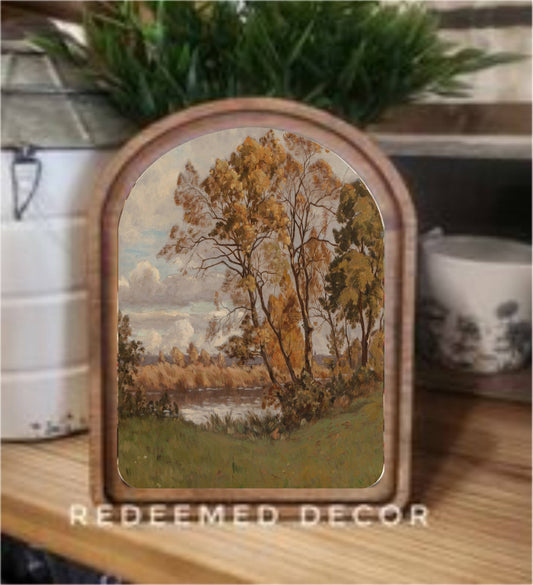 Arch top wood framed canvas art depicting autumn trees and riverside landscape