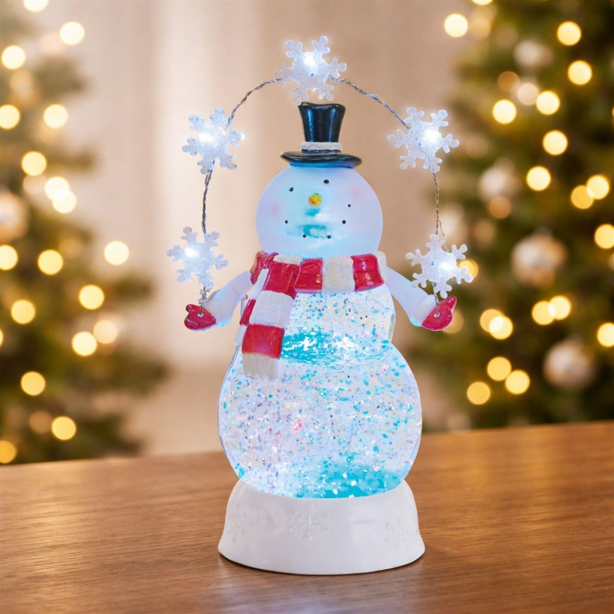 Illuminated snowman snow globe with glitter swirl body, top hat, red scarf, and LED snowflake garland