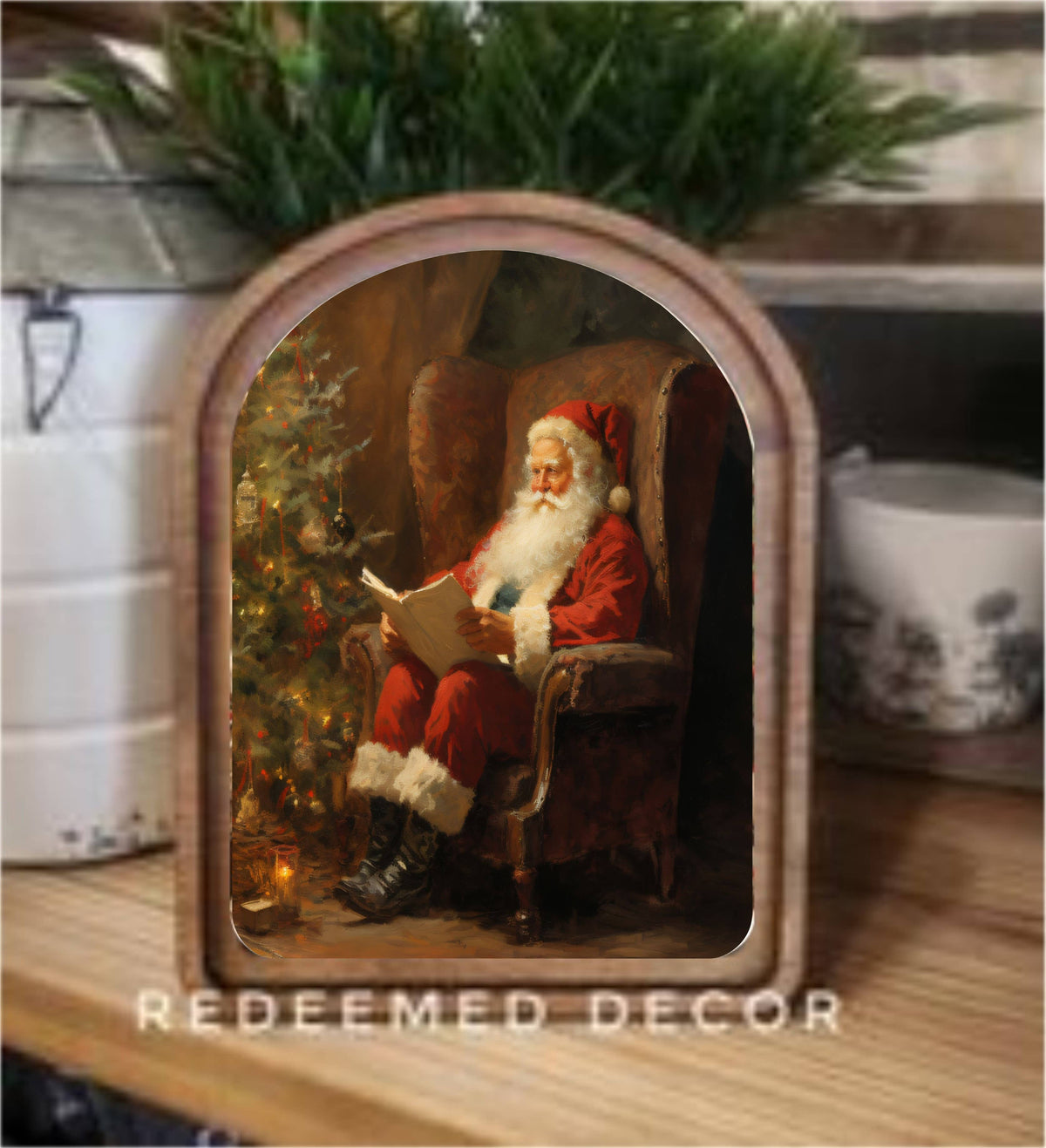 Arch-top framed canvas art of Santa Claus reading beside a Christmas tree