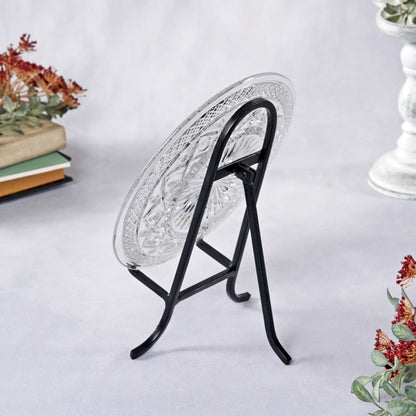 Black wrought iron easel stand displaying a cut crystal glass plate, side view