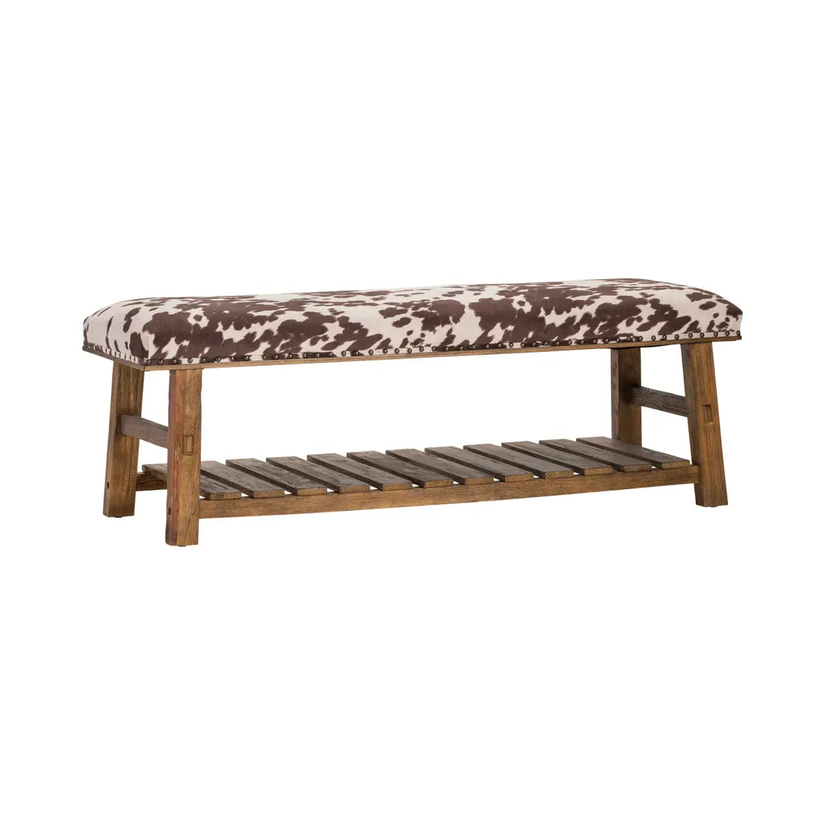 Upholstered bench with brown and white cowhide print cushion and rustic wood frame with slatted shelf