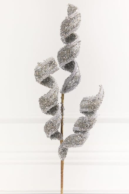 Decorative artificial spray with curling spiral leaves covered in silver glitter, on a stem