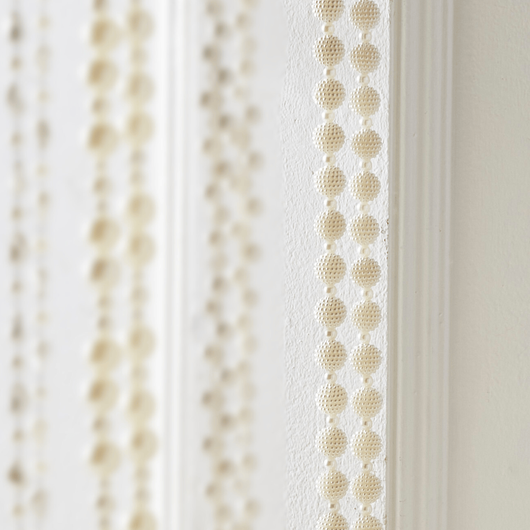 Close-up of pearl beaded garland with textured round beads in vertical rows, cream white finish