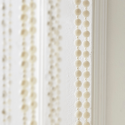 Close-up of pearl beaded garland with textured round beads in vertical rows, cream white finish