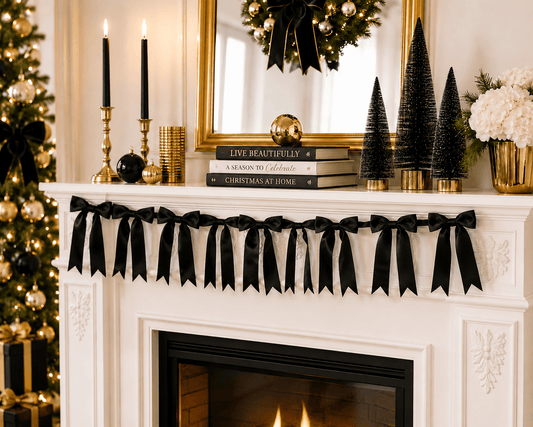 Black satin bow garland draped along a white fireplace mantel in a holiday setting