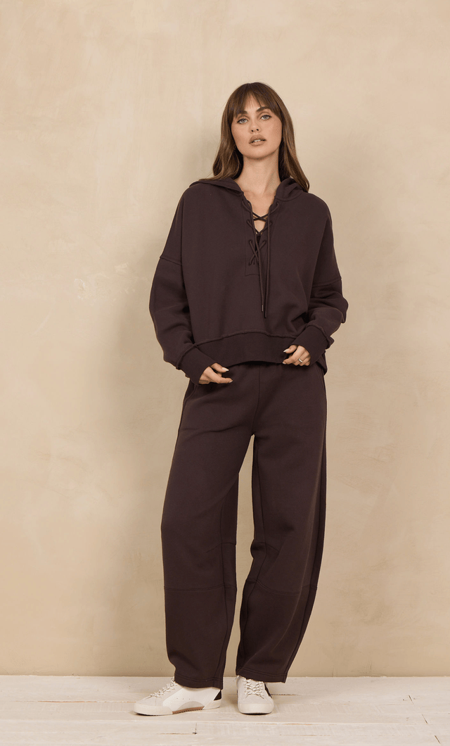 Cropped lace-up hoodie in dark brown with matching wide-leg sweatpants, front view on model