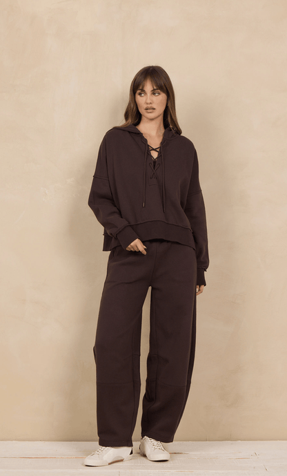 Oversized lace-up hoodie in dark brown worn with matching wide-leg sweatpants, front view