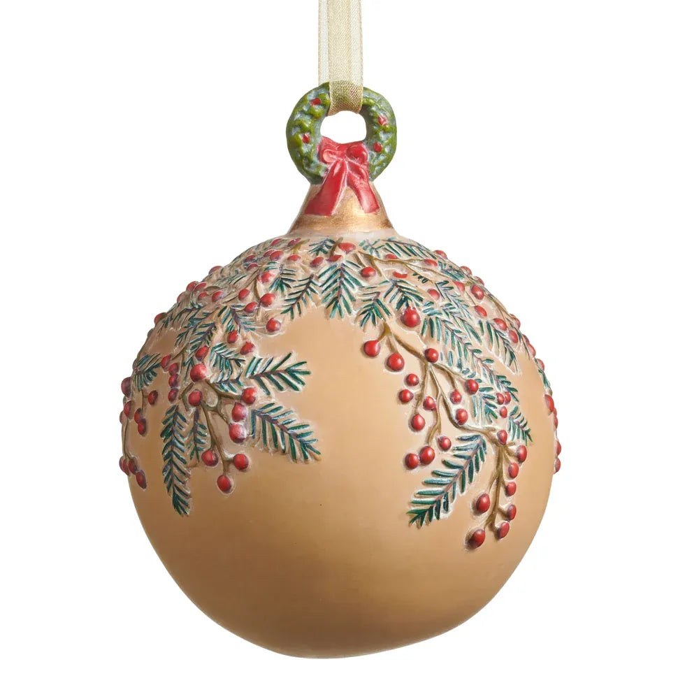Round gold ball ornament with embossed pine branches, red berries, and wreath-shaped cap, hanging view