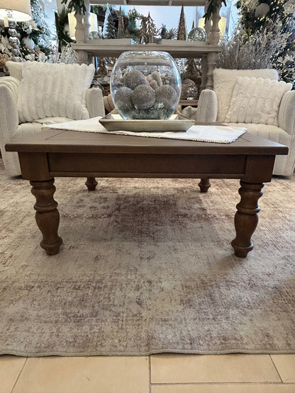 Rustic brown knotty pine wood coffee table with turned legs on vintage rug