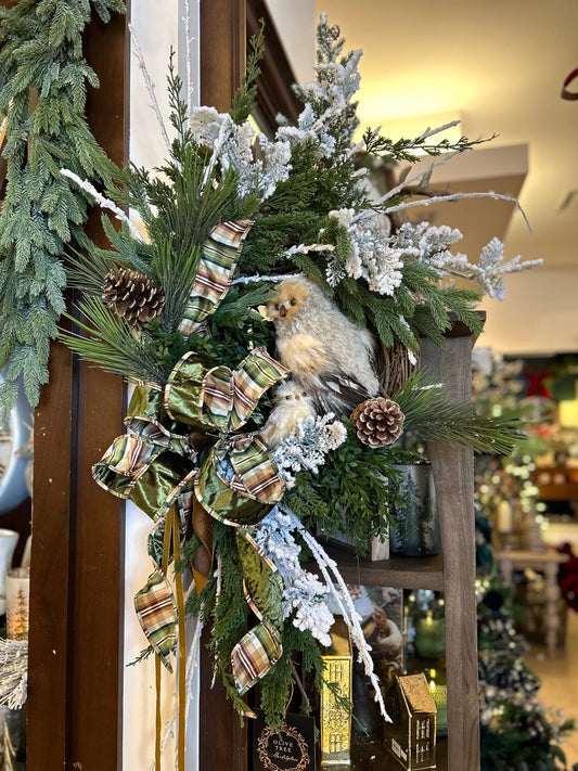 Custom winter wreath with owl figurines, flocked branches, pine cones, and plaid ribbon