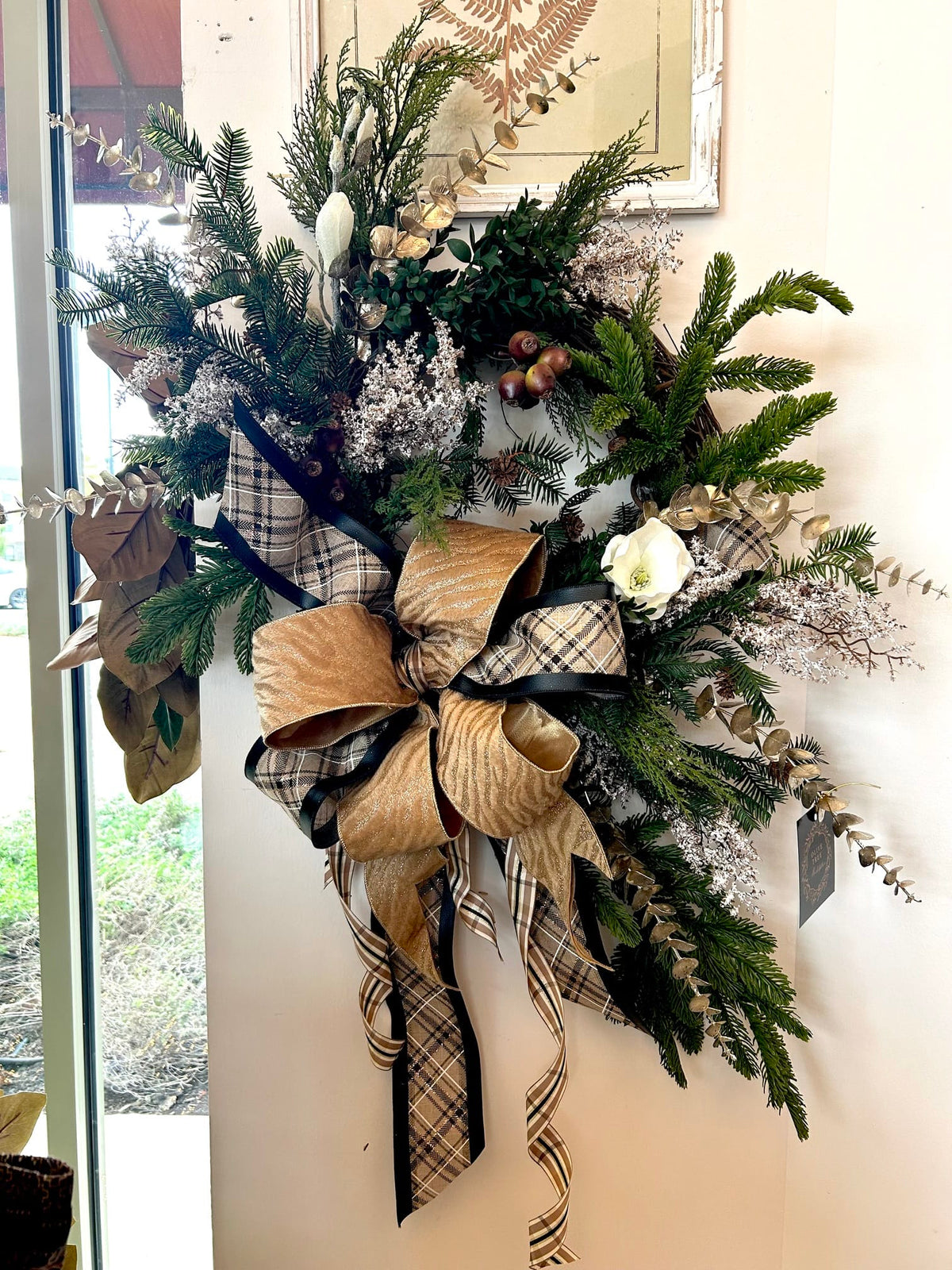Elegant woodland wreath with pine, eucalyptus, gold shimmer bow, and black plaid ribbon