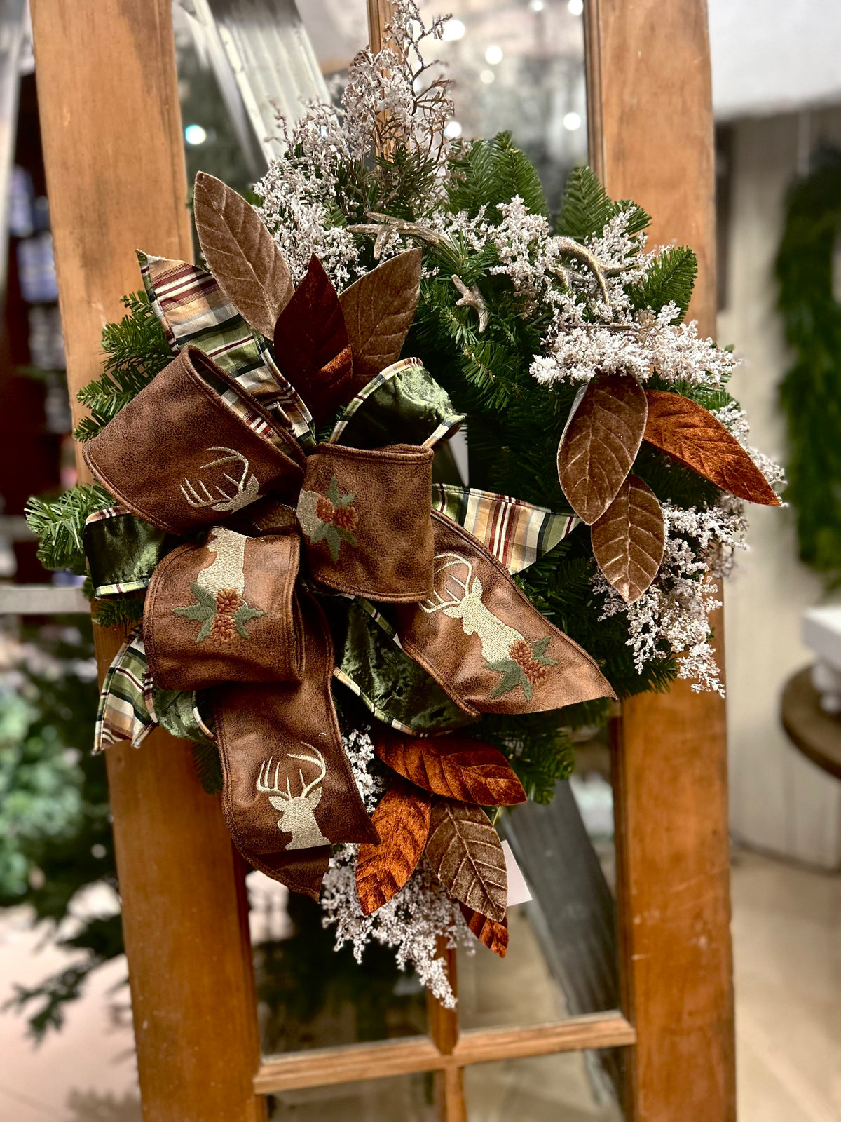 Brown deer ribbon woodland Christmas wreath with copper magnolia leaves and frosted greenery