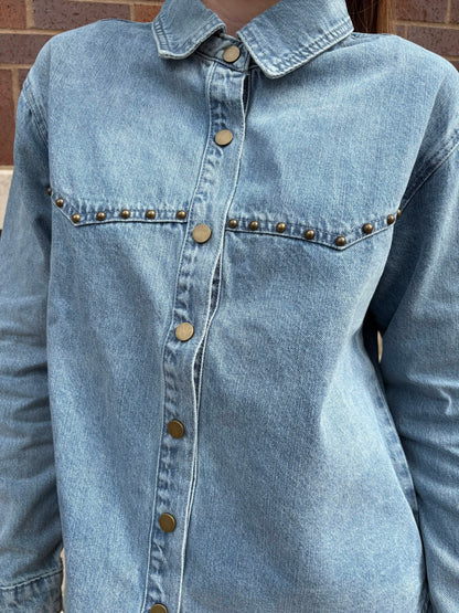 Light wash denim shirt with brass snap buttons and gold stud pocket detail