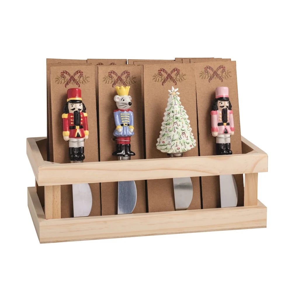 Nutcracker-themed cheese spreader set with four holiday figurine handles in wooden crate