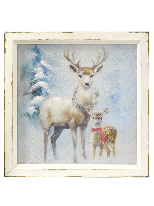 Framed winter painting of a standing stag and spotted fawn in a snowy forest scene