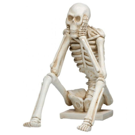 Cream resin skeleton figurine seated in thinking pose on small base