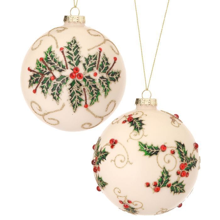 Two cream glass ball ornaments with holly leaves, red jewel berries, and gold glitter vine details