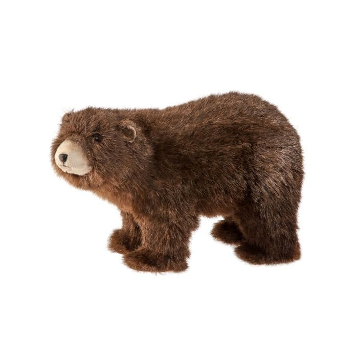Realistic faux fur stuffed brown bear in standing four-legged pose, side view