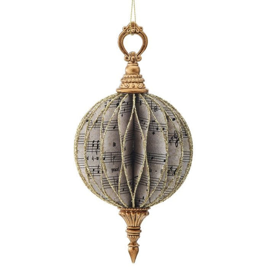 Vintage-style round finial ornament with sheet music print and gold glitter trim, hanging view